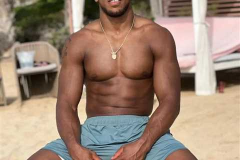 Anthony Joshua shows off shredded physique and looks ready for battle while sitting on beach ahead..